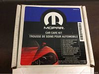 Box of the Mopar Car Care Kit showing Mopar logo and a close-up of a red sports car headlight.