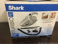 Box of Shark Turbo Corded Hand Vacuum featuring product image and description labeling features such as ultra lightweight, quick cleaning, and included attachments.