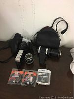Full view of all items in the lot including the Pentax camera, lenses, flash, filters, and case arranged on a table.