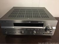 Front view of Yamaha RX-V757 AV receiver with control knobs, power button, and input options visible.