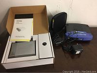 Three routers: Belkin N150 Router, D-Link D1604 in box with manual, Linksys BEFSR41 router with power adapter and cables.