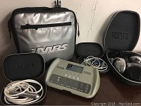 Control unit, accessory cases, headphones and cables arranged on table