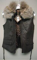 Front view of a brown leather women's waistcoat with raccoon fur collar, zipper front, and flap pockets.