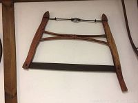 Full view of the antique bow saw with wooden frame, metal blade and tensioning wire, showing size and condition.