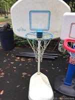 Large white and blue children's basketball hoop with net and base visible, showing signs of wear