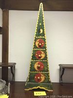 Full view of the tall wooden cubby painted with moon and stars folk art, showing its overall shape and decoration.