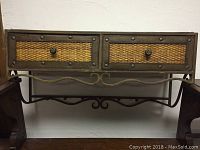 Front view of vintage shelf showing two rattan drawers and metal frame with hanging hooks