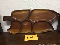 Front view of the wooden serving tray showing 5 uniquely shaped compartments and a handle extension.