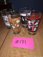 Four 16 oz Beatles-themed glasses seen together showing different band member artwork and colors