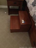 Wood bed stairs from a side angle showing two steps and brown wood finish.