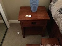 Front view of the wood night stand with drawer closed, showing top surface and drawer handle.