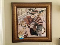 Frontal photo of the signed painting featuring a woman and a leopard with luggage in the background; shows the frame and painting details.