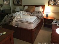 Front view showing headboard, footboard, mattress and bedding on the storage bed frame