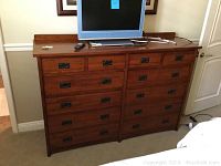 Front view of the 12-drawer dresser with a television on top