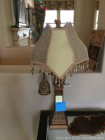 Full front view of lamp showing main shade, swing arm light, and base