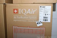 Two stacked cardboard boxes with IQAir branding and product illustration