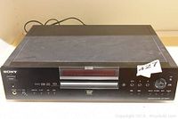 Front view of black Sony DVD player model DVP-NS900V showing disc tray, display, and control buttons.