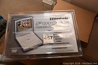 Clear image of Mintek 5 inch TFT monitor portable DVD player in original sealed packaging showing model number and key features.