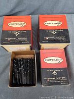 Three original boxes of Cleveland twist drill bits with black and red color scheme, showing brand name and quality mark.