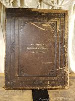 Front cover view of large brown embossed leather book showing the title 'American Historical & Literary Curiosities' in gold lettering and wear marks.
