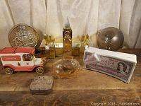 Full view of all items in lot showing the Canada Post truck, Parliament Hill model, piggy bank, silver coin, globe, and $1000 bill bank
