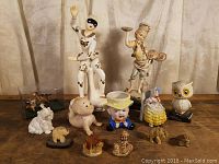 Wide shot of the entire lot showing all figurines arranged on a surface with curtain backdrop