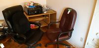 Photo showing black office chair, burgundy office chair, desk with printer and supplies