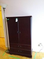 Full view of wooden hutch with floor lamp beside it, showing dark wood finish and metal lamp base.