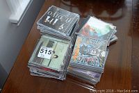 Stacks of used music CDs from various artists including Marillion and Il Divo, placed on a table for cataloging.