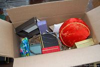 Opened cardboard box showing assorted costume jewelry and small boxes