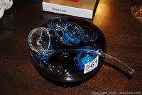 Image showing dark glass punch bowl filled with small black and blue punch cups and clear glass ladle