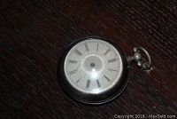 Photo of Cardinal pocket watch showing front dial with Roman numerals but missing hands.