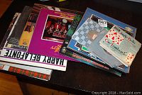 Stack of vinyl LP albums visible with colorful cover art, including Harry Belafonte, Scottish music LP, and others