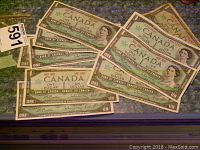 Top view showing the ten 1967 Canadian one dollar bills fanned out, visible Queen Elizabeth II portraits and Centennial markings.
