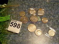 Overview of all ten coins on countertop: three silver dollars and seven half dollars.