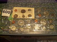 Full view of all four years' coin sets laid out, sealed in plastic sheets with visible coin designs.