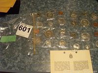 Four Canadian coin sets from years 1965, 1966, 1967, and 1968 sealed in plastic holders on blue surface.