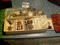 Overview of all medals in box, bag of badges and buttons, stamps and knitted pouch