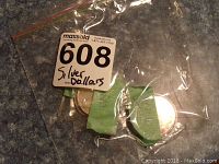 Small plastic bag containing three Canadian silver dollar coins with a MaxSold lot sticker labeled 'Silver Dollars'.