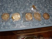 Five Canadian silver dollar coins dated 1963, two 1966 coins, 1965 and 1967. Coins show wear and patina, some in plastic holders.