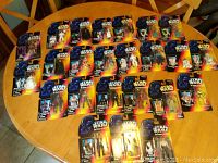 24 sealed Star Wars action figures laid out on a table