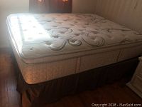 Queen size Serta mattress with tufted top and floral designs, shown on box spring and frame.