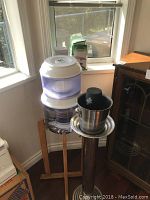 Wide shot of the purified water dispenser with metal stand and wine chiller bucket showing all components together.