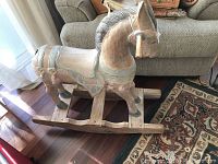 Full side view of the wooden rocking horse showing carved details and curved rockers.