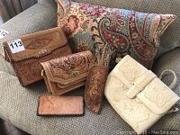 Full set of three leather purses, one holster, and eyeglass case on a paisley cushion