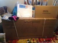 Overview of boxed crib, changing pad box and mattress in original packaging