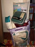 Photo showing packed bedding set in themed storage bag including pillows, comforters, and packaged electric heated throw.