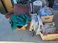 Wide view of assorted linens, pillows, and the boxed electric blanket showing lot contents.