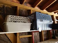 Photo of two pet transport cases side by side on a shelf, showing their size difference and design.