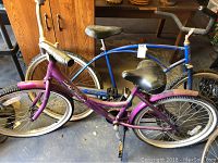 Photo showing side view of both bicycles together inside a garage or storage area.